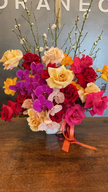 Colourful bouquet of flowers with a wooden base on a dark surface