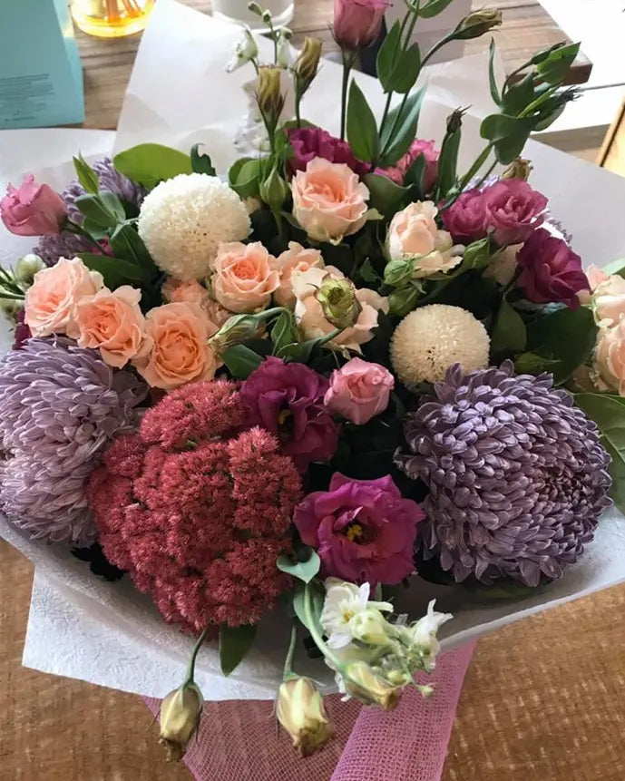 Traditional round bouquet of seasonal flowers in shades of pink, purple, and maroon, elegantly wrapped in Gladesville florist Floranectar Flowers signature style.
